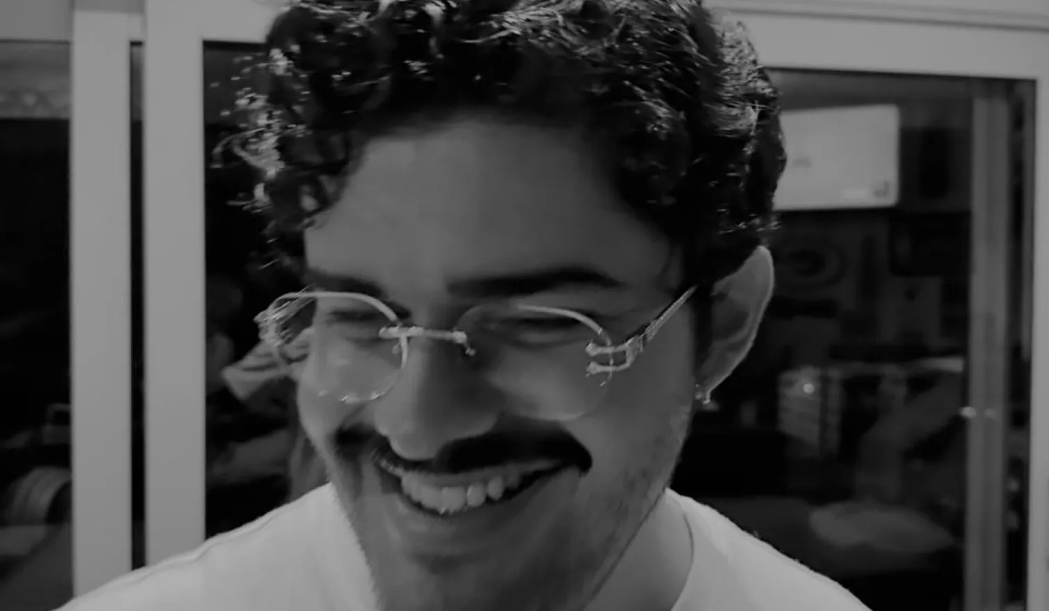Foto de Mikezio sonriendo en blanco y negro dentro de su estudio