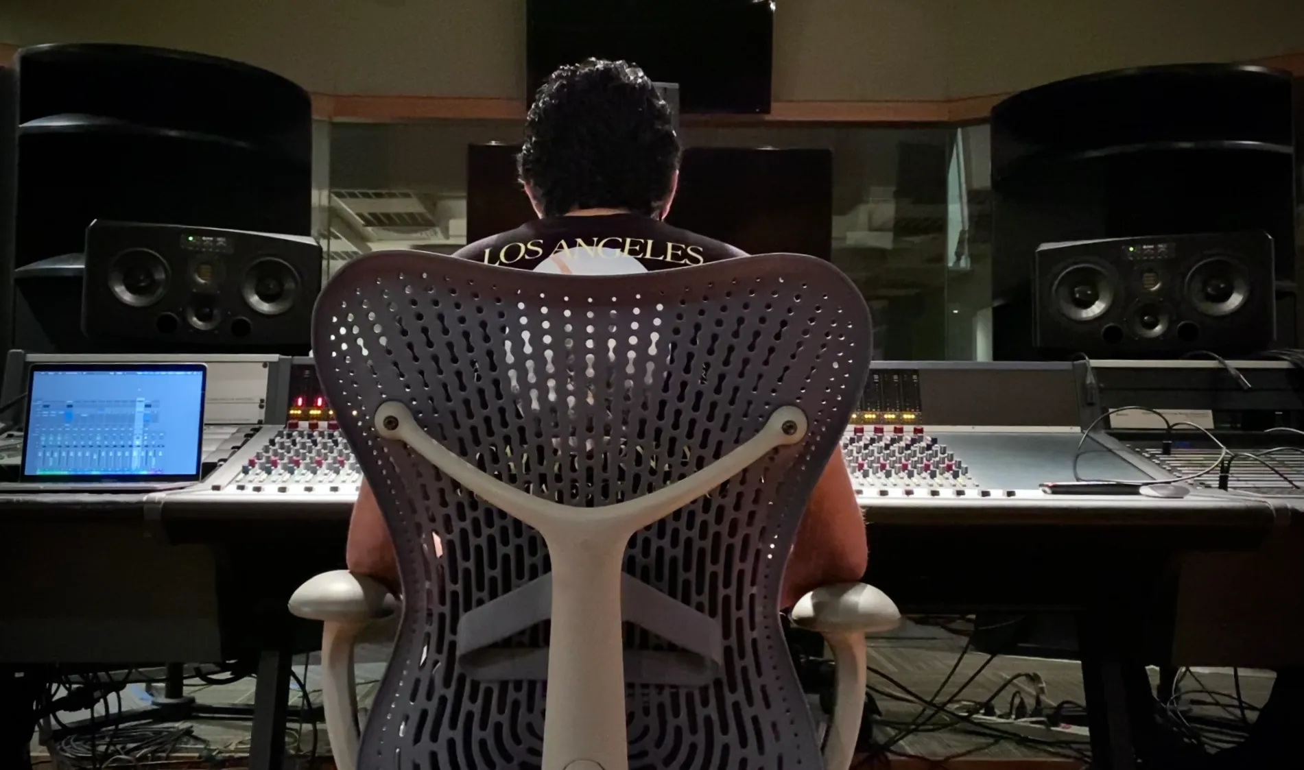 Mikezio sentado en el sillón de su estudio con el logo de Zio Records atrás.